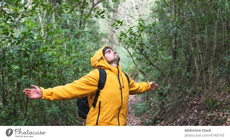 Mann mit Wollmütze im Wald stehend Wanderer Natur Trekking Baum Reise Augen geschlossen ausgestreckte Arme erkunden Ausflug Wanderung Wälder Aktivität Abenteuer