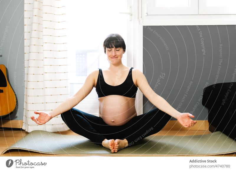 Fitte schwangere Frau meditiert nach Yoga zu Hause meditieren Schmetterlingspose Lächeln üben heimwärts Pose Asana Schwangerschaft warten Glück erwarten