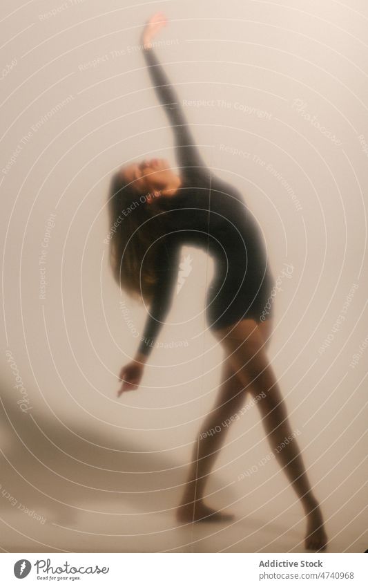 Frau tanzt in der Nähe der weißen Wand Tanzen Tänzer ausführen Anmut Choreographie Hobby feminin Stil üben schlanke Dame Probe Barfuß Atelier sich[Akk] bewegen