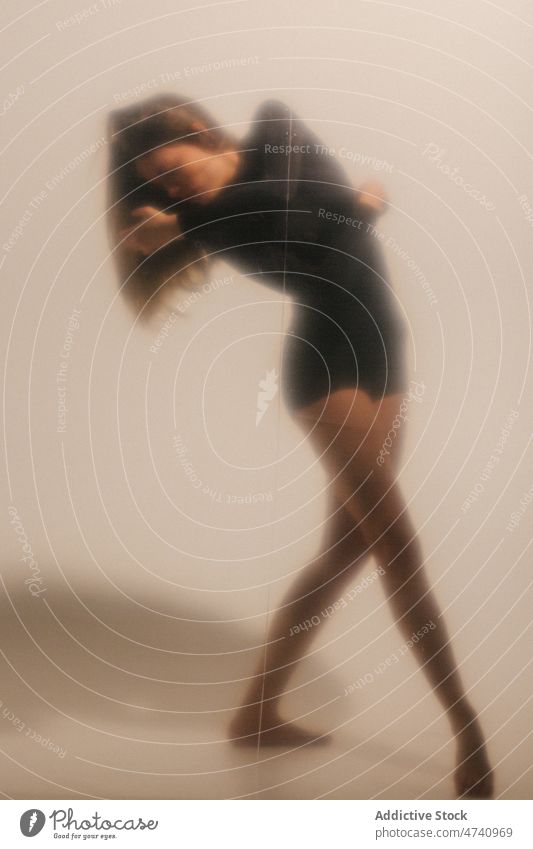Frau tanzt in der Nähe der weißen Wand Tanzen Tänzer ausführen Anmut Choreographie Hobby feminin Stil üben schlanke Dame Probe Barfuß Atelier sich[Akk] bewegen