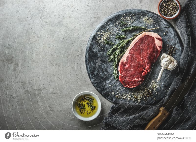 Lebensmittel Hintergrund mit rohem Rindfleisch Steak auf Marmor Schneidebrett Rohfleisch Rindersteak Lebensmittelhintergrund Murmel Rosmarin Knoblauch Olivenöl