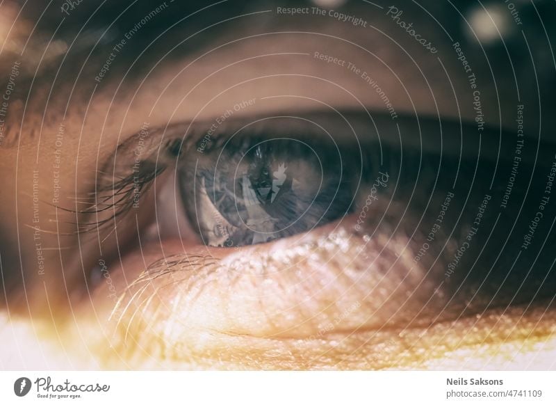 Menschliche Schönheit Auge. Makroaufnahme. Blaues menschliches Auge Iris Makroaufnahme. Helles Licht. Horizontales Bild. Vintage Farbe aussehen. abstrakt