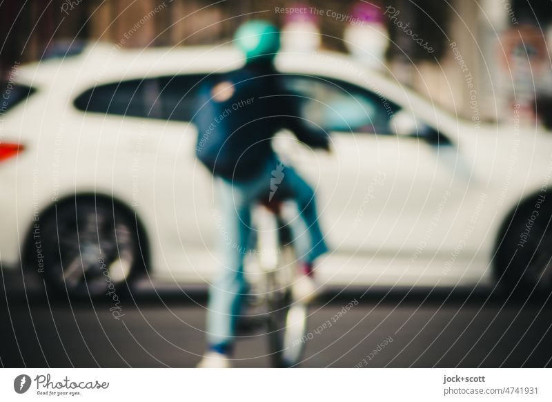Fahrradfahrer möchte eine mit Autos befahrene Straße überqueren defokussiert Lifestyle Verkehr Mensch warten Überqueren Verkehrsmittel Straßenverkehr