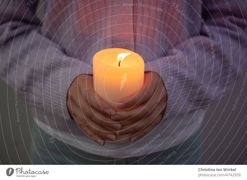 Flackernde Kerze in den Händen einer jungen Frau Kerzenschein Kerzenflamme Kerzenlicht festhalten leuchten brennen Hoffnung Glaube Liebe Besinnung Friedenslicht