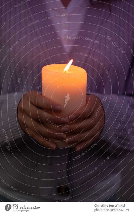 Eine brennende Kerze in den Händen halten Friedenslicht Gedenken Trauer Besinnung Liebe Glaube Hoffnung Kerzenschein Kerzenlicht Kerzenflamme festhalten