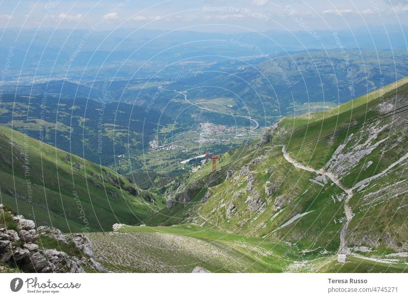 Ein Blick auf ein Tal und einen Wanderweg von oben Berge u. Gebirge wandern Nachlauf grün blau Bäume Steine Landschaft