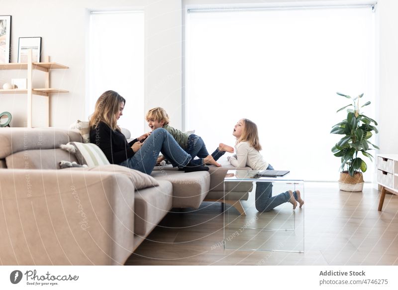 Kinder in der Nähe der Mutter, die auf der Couch ein Tablet benutzt Wohnzimmer Tablette Abhängigkeit Browsen online süchtig machend absorbieren ignorieren