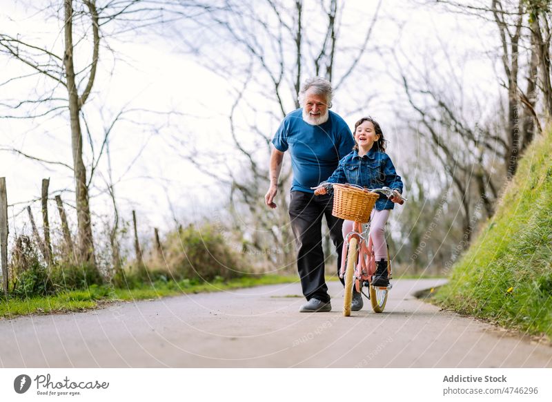 Großvater unterrichtet Mädchen beim Fahrradfahren auf dem Lande Hobby Freizeit Kindheit Zeit verbringen Mitfahrgelegenheit Landschaft Hilfsbereitschaft