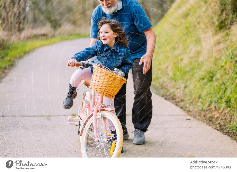 Großvater unterrichtet Mädchen beim Fahrradfahren auf dem Lande Hobby Freizeit Kindheit Zeit verbringen Mitfahrgelegenheit Landschaft Hilfsbereitschaft