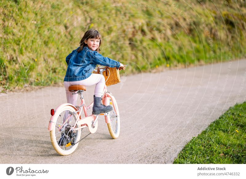 Nettes Mädchen auf dem Fahrrad sitzend Kind Park Hobby Freizeit Zeitvertreib Kindheit Erholung Mitfahrgelegenheit Korb Aktivität Sommer Verkehr Lächeln