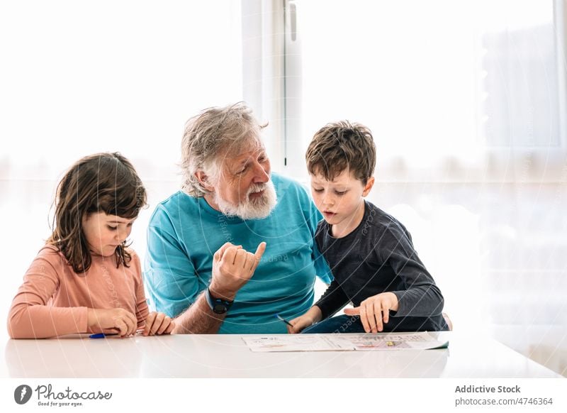 Großvater lehrt Enkelkinder das Schreiben Kinder lernen schreiben Hausaufgabe Wissen Bildung primär Kognition heimwärts klug sorgsam Junge Mädchen