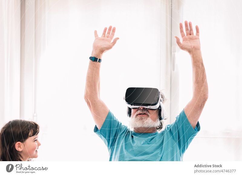 Großvater mit VR-Brille in der Nähe eines Mädchens Headset Schutzbrille erkunden Cyberspace futuristisch Virtuelle Realität eintauchen Simulator modern älter