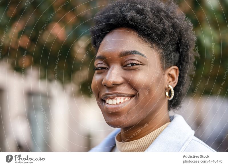 Lächelnde schwarze Frau in der Stadt Straße Großstadt Vorschein Stil feminin genießen urban Gebäude Afroamerikaner Sommer froh Glück lässig positiv Inhalt