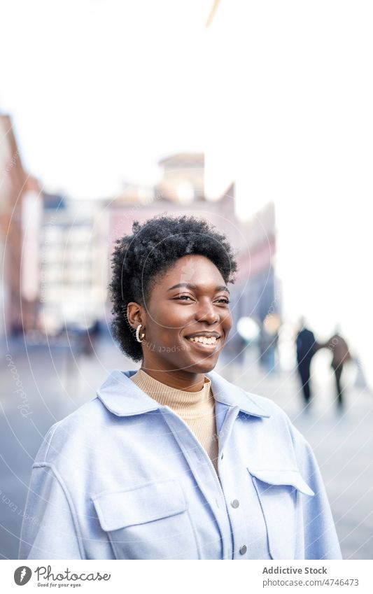 Lächelnde schwarze Frau in der Stadt Straße Großstadt Vorschein Stil feminin genießen urban Gebäude Afroamerikaner Sommer froh Glück lässig positiv Inhalt