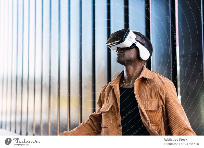 Schwarzer Mann erforscht virtuelle Realität in VR-Headset Schutzbrille Großstadt erkunden Cyberspace futuristisch Virtuelle Realität Gebäude Simulator modern