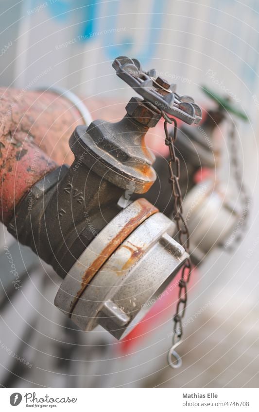 Rostiger Hydrant mit Kette Hydrantenkasten Wasser Wasserrohr verrostet Metal Eisen Gußeisen Rad Schieberegler Regler Wasserleitung Wasserrohrleitung Rot