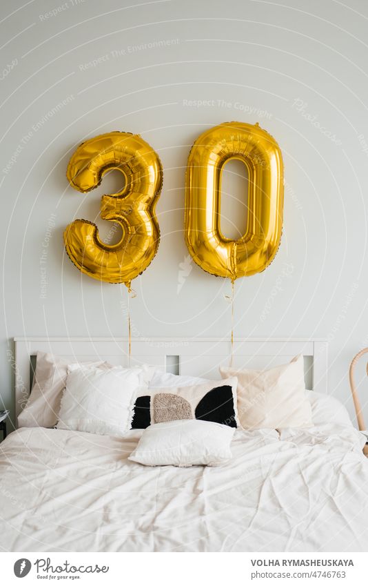 Heliumballons für 30 Jahre über dem Bett des Geburtstagskindes oder des Geburtstagskindes im Haus. Festlicher Morgen Wand Luftballon Raum Innenbereich Licht