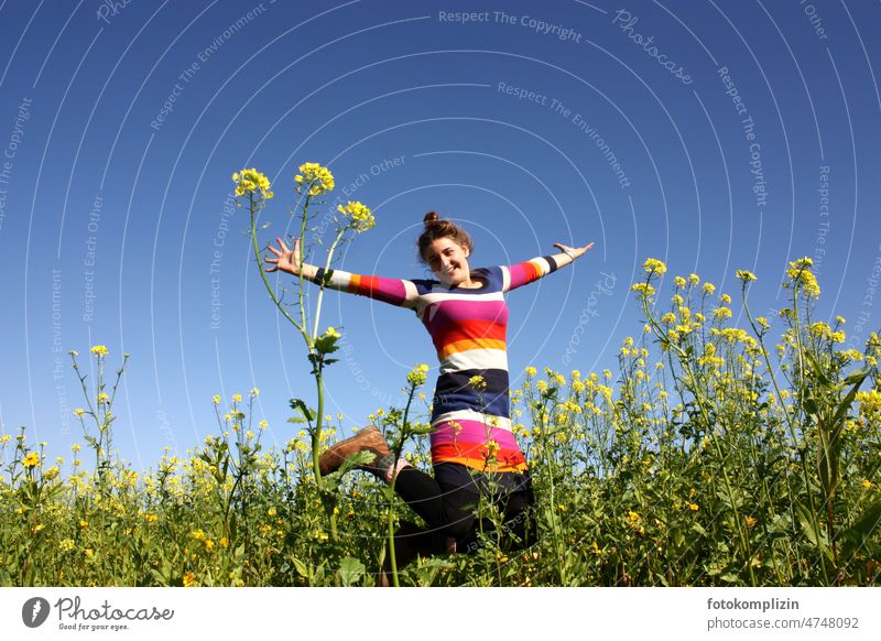 junge Frau springt in einem blühendem Rapsfeld Freude springen hüpfen Mädchen Glück freuen frei Lebensfreude Fröhlichkeit Bewegung Natur feminin Zufriedenheit