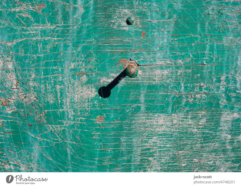 Nagel und sein Schatten an der verwitterten Wand nageln grün alt Holz getüncht Oberflächenstruktur Russisch Stil Anstrich schäbig desolat gemalt Sonnenlicht