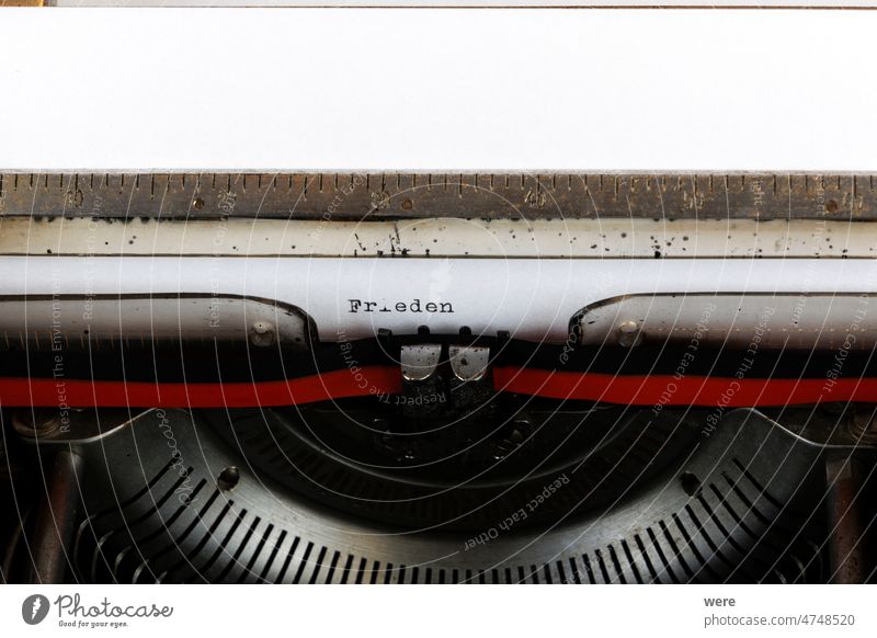 Das deutsche Wort Frieden geschrieben auf einer alten mechanischen Schreibmaschine Deutscher Text: Frieden Brief stoppen antik schwarz Farbband Tastenfeld