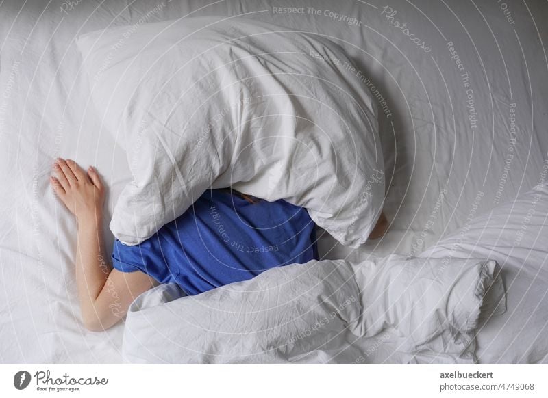Frau schläft im Bett mit Kissen über ihrem Kopf schlafen Kopfkissen müde Person Schlafmütze Spätaufsteher Langschläfer unkenntlich Sonnenlicht Licht Geräusch