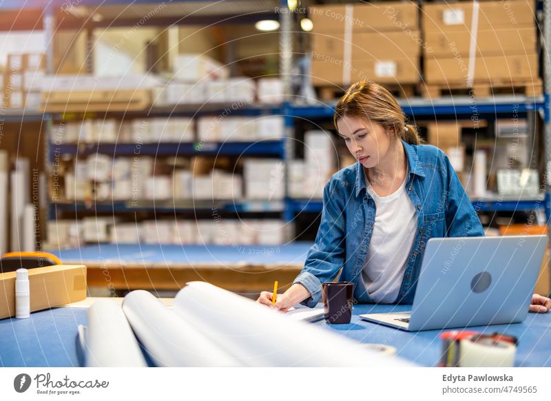 Frau benutzt Laptop im Lagerhaus Business Ladung selbstbewusst liefernd Versand Verteilung Mitarbeiter Fabrik Ware industriell Industrie Job