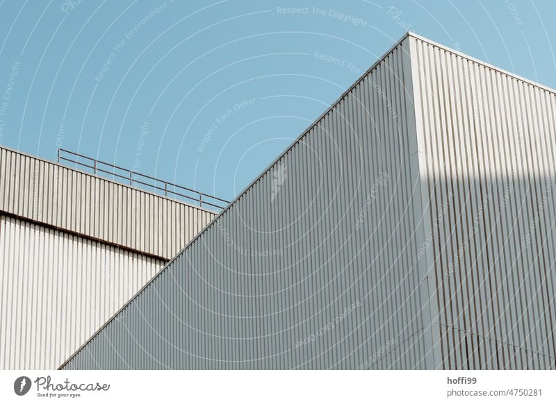 Weisse Wellblechfassaden einer Lagerhalle im Hafen vor blauem Himmel Architektur Industriefassade Blauer Himmel Schuppen minimalistisch Hafengebäude