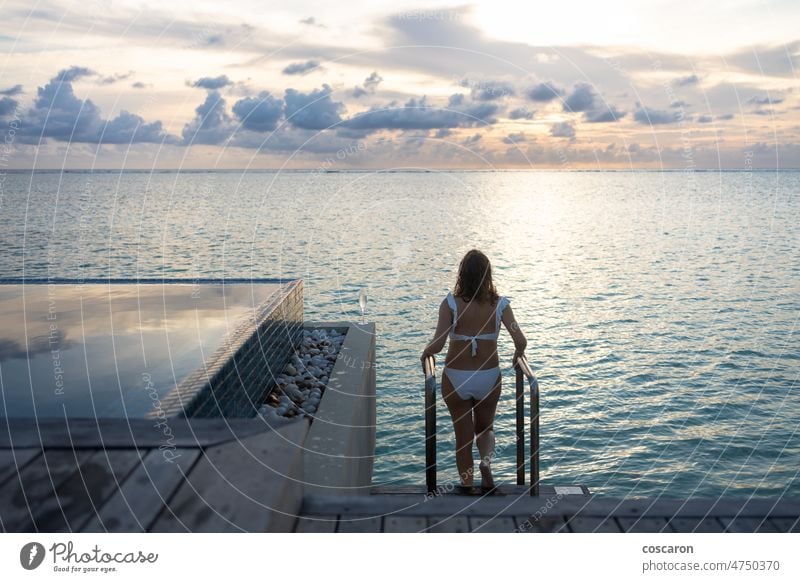 Frau in einer Überwasservilla auf den Malediven asiatisch Strand Bikini blau Körper Bungalow Karibik Mädchen Feiertag Feiertage Hotel Insel Laufmasche Freizeit