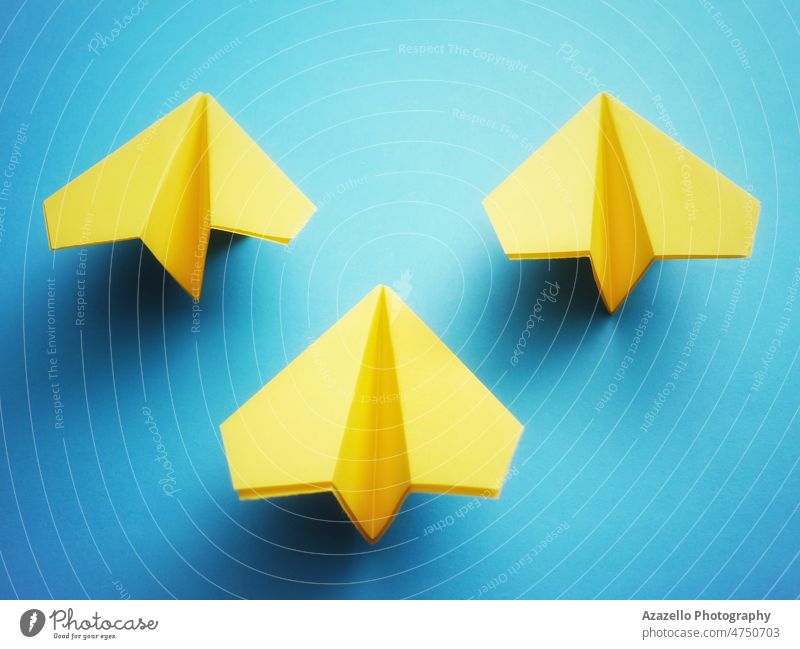 Gruppe von drei gelben Papierdüsen auf blauem Hintergrund. Unterstützung Fluggerät Bündnis Bomber Tschernobyl Farben Konzept Konflikt Handwerk Dombass EU Europa