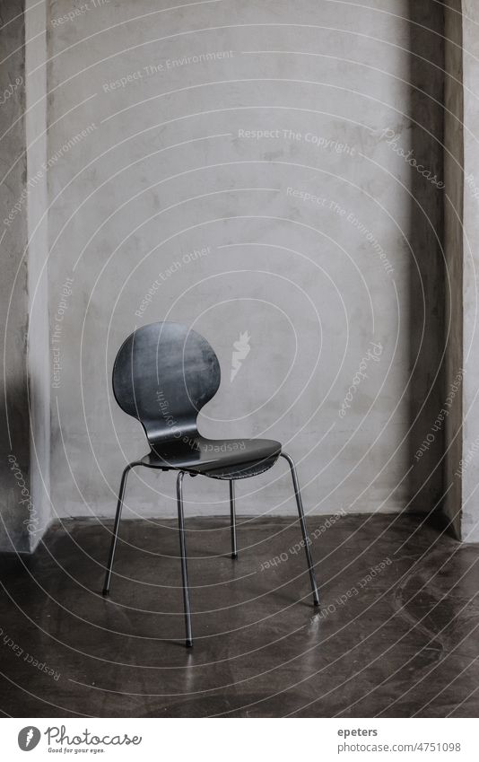 Leerer Stuhl vor einer Betonwand in einem Fotostudio leer leerer Stuhl Stock grau fehlend keine Person Fotografie Schatten Atelier vertikal Wand Menschenleer