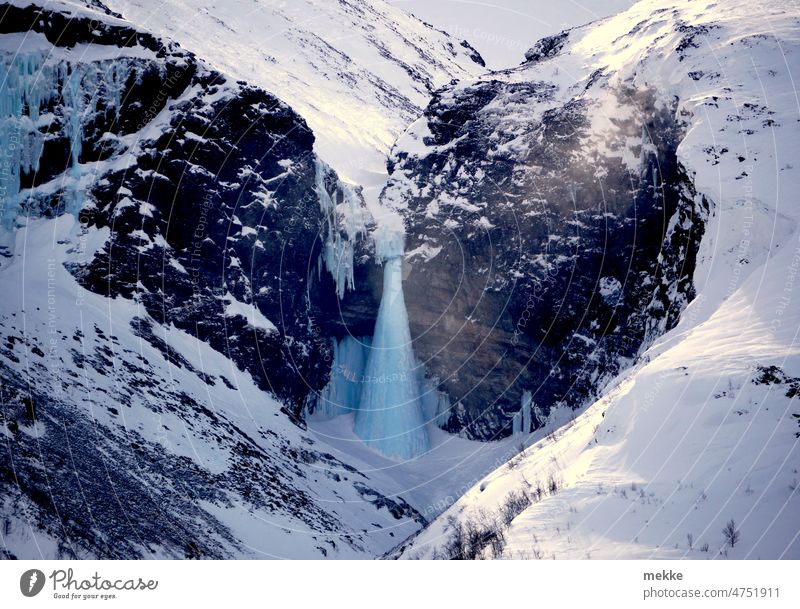 Eisfall in Zuckertütenform inmitten herzförmiger Felswand Wasserfall Winter Natur Fluss Felsen Landschaft gefroren Schnee Frost kalt erstarrt Herz Gebirge