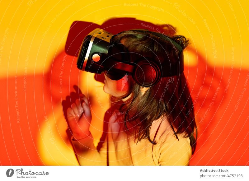 Kleiner Gamer mit VR-Brille Junge Spieler fettarm Wand zuschauen Videospiel erkunden Rotlicht neonfarbig leuchten Farbe Kind Mädchen Monochrom Frau hell Headset