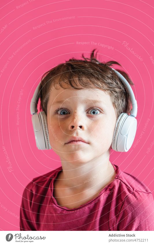 Junge hört mit kabellosen Kopfhörern im Studio Lieder zuhören erstaunt benutzend Wiedergabeliste Drahtlos Musik Freizeit Apparatur Gesang Lächeln Kind lebhaft