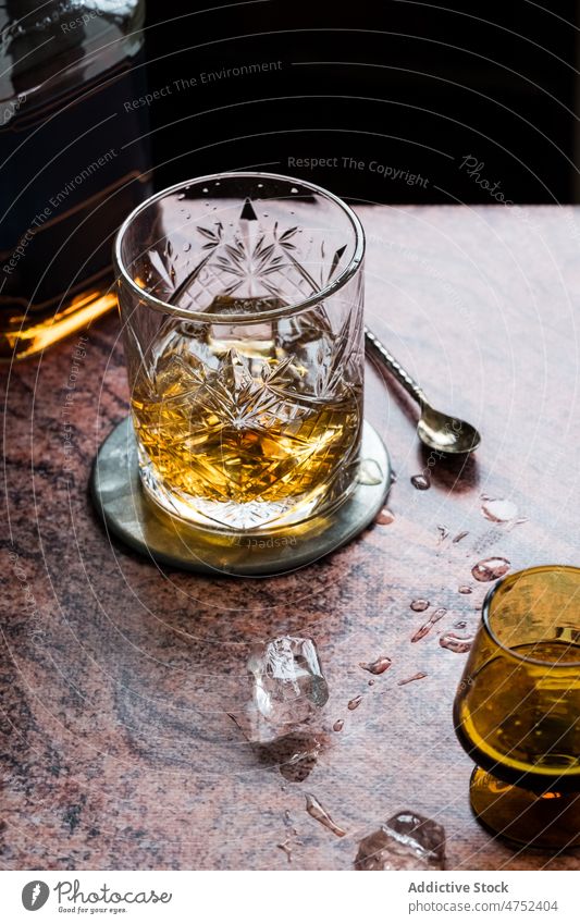 Ein Glas Whiskey auf dem Tisch eines Restaurants Eis Alkohol nass Dienst Portion Löffel trinken Getränk Schnaps Steine Broadway Pub Kristalle Exquisit cool kalt