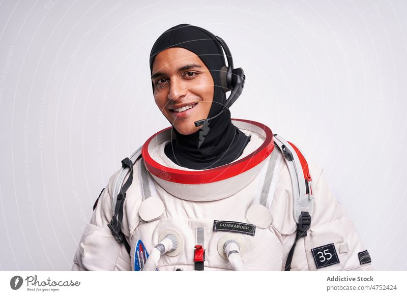 Lächelnder ethnischer Astronaut im Raumanzug mit Headset für den Flug ins Weltall Mann Schmuckkörbchen bereit Erde Porträt hispanisch Atelier Fundstück