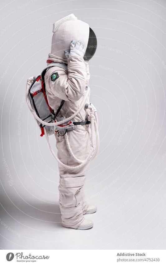 Astronaut nimmt im Studio den Helm des Raumanzugs ab Mann Kosmonaut Schmuckkörbchen Schutzhelm Abheben Sicherheit behüten Weltall Astronomie männlich Model