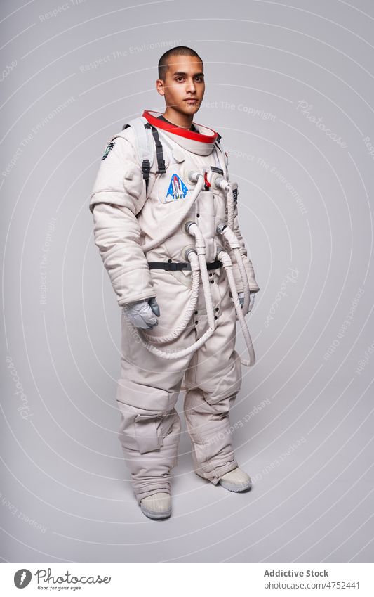 Tapferer ethnischer Kosmonaut im Raumanzug im Studio bereit zum Flug Mann Astronaut Weltall Missionsstation Latein Astronomie Fundstück Uniform männlich