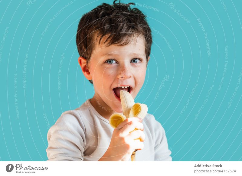 Fröhlicher Junge isst reife Banane Kind Kindheit Frucht essen organisch gesunde Ernährung Porträt natürlich Lebensmittel heiter Glück positiv frisch süß froh