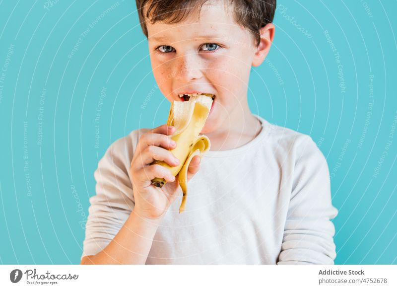 Fröhlicher Junge mit reifer Banane Kind Kindheit Frucht essen organisch gesunde Ernährung natürlich Lebensmittel heiter Glück positiv frisch süß froh Atelier