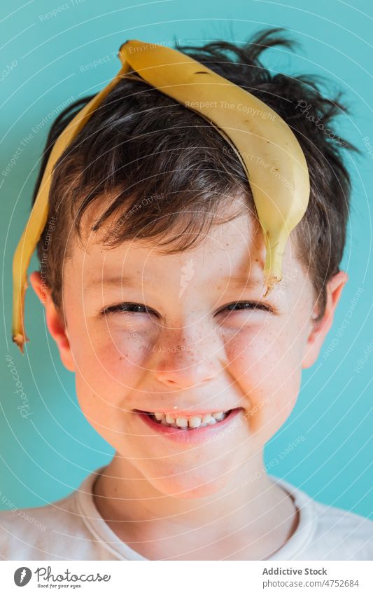 Lustiger Junge mit Bananenschalen auf dem Kopf Kind sich[Akk] schälen Spaß haben Kindheit sorgenfrei spielerisch Lächeln Frucht heiter Porträt Glück positiv