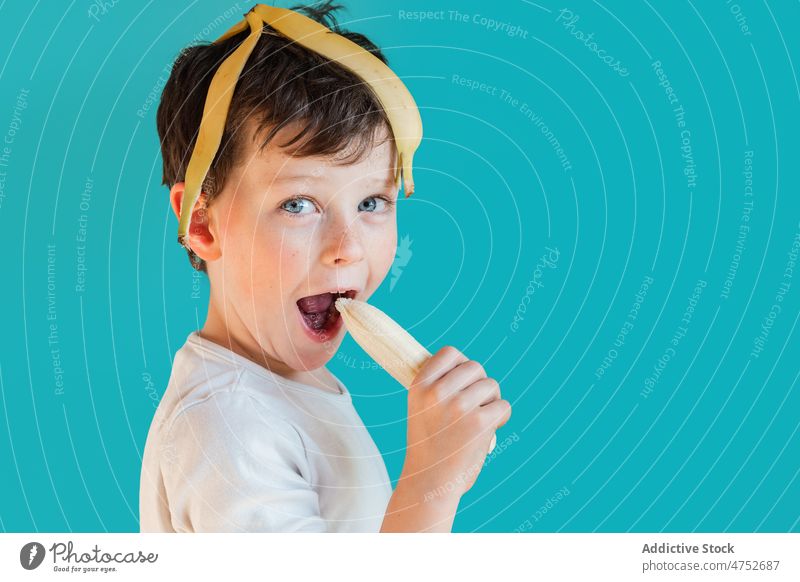 Lustiger Junge mit Bananenschalen auf dem Kopf Kind sich[Akk] schälen Spaß haben Kindheit sorgenfrei spielerisch Lächeln Porträt Frucht essen heiter reif Glück