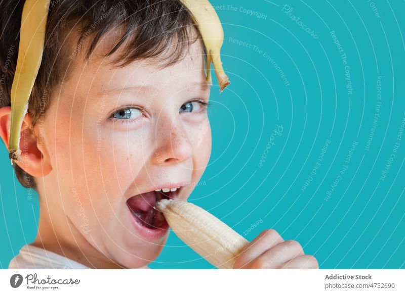Lustiger Junge mit Bananenschalen auf dem Kopf Kind sich[Akk] schälen Spaß haben Kindheit sorgenfrei spielerisch Lächeln Porträt Frucht essen heiter reif Glück