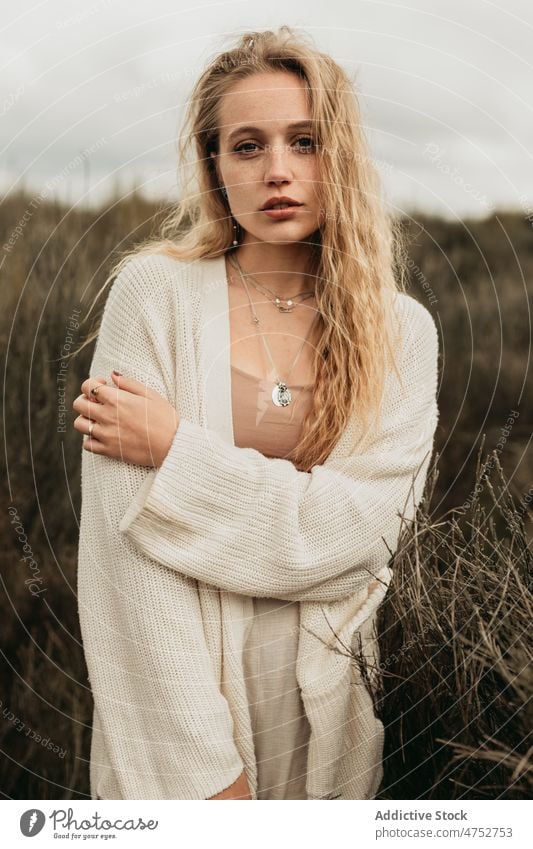 Frau steht auf einem grasbewachsenen Feld auf dem Lande Landschaft Porträt Natur Vorschein feminin Stil attraktiv jung ländlich blond Umwelt trist rustikal