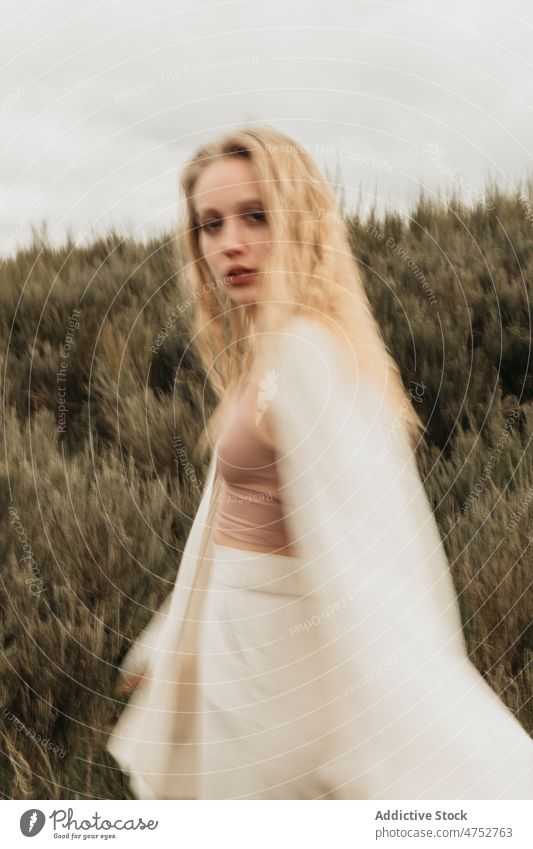 Frau steht auf einem grasbewachsenen Feld auf dem Lande Landschaft Porträt Natur Vorschein feminin Stil attraktiv jung ländlich blond Umwelt trist rustikal