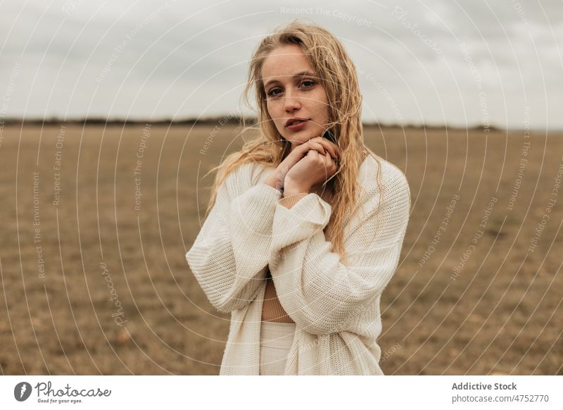 Frau steht auf einem grasbewachsenen Feld auf dem Lande Landschaft Porträt Natur Sommersprossen Vorschein feminin Stil attraktiv jung ländlich blond Umwelt