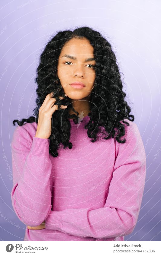 Nachdenkliche schwarze Frau schaut in die Kamera Vorschein Frisur feminin Stil trendy Atelier attraktiv charmant Porträt Afroamerikaner Dame schön Charme Licht