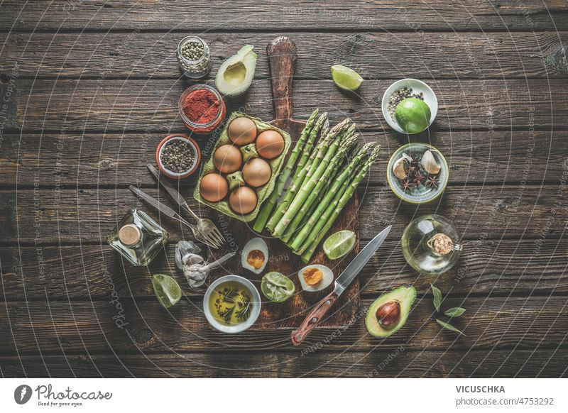 Verschiedene gesunde Kochzutaten: Grüner Spargel, Eier, Gewürze, Avocado, Limette, Olivenöl verschiedene Gesundheit Essen zubereiten Zutaten grün Haufen Kalk