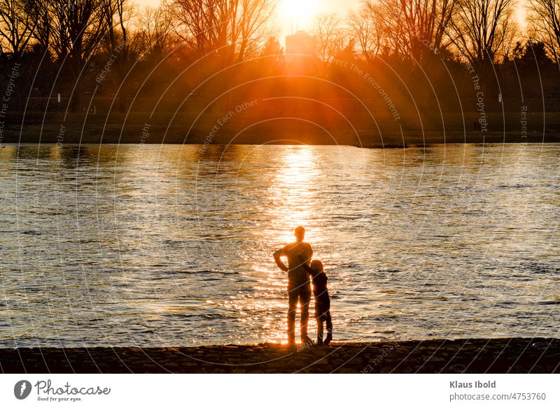 Vater und Tochter vor einem Sonnenuntergang am Rhein bei Düsseldorf Landschaft Nature Themen Paar RomantikIdylle romantisch idylle. schönheit idylle schön Fluss