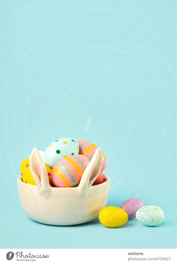Frohe Ostern. Bunte Ostern gemalt Eier in einem Hase Ohren Schüssel mit Kopie Raum bemalte Eier frohe Ostern abstrakt süß Stillleben Hähnchen Textfreiraum