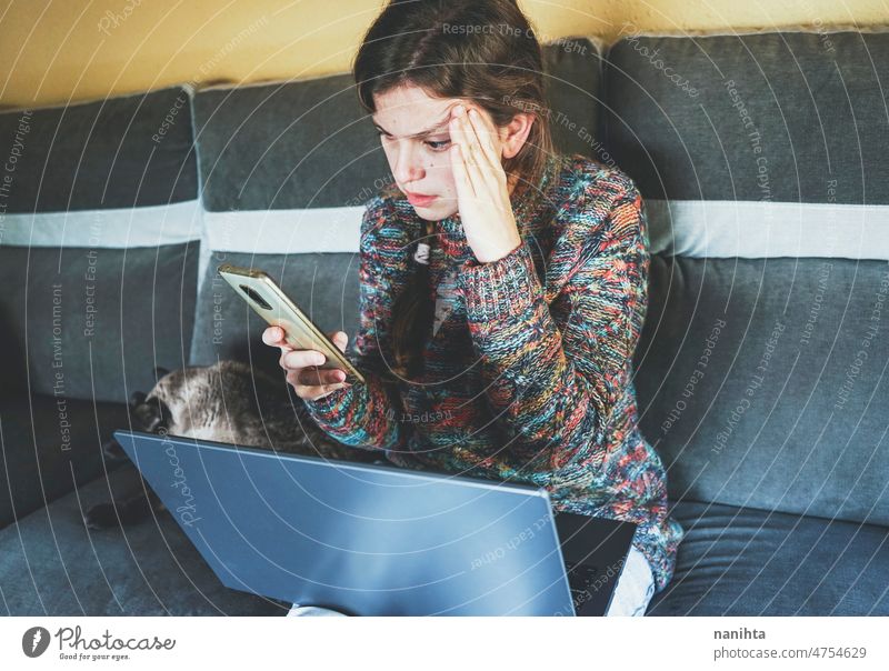 Junge und besorgte Frau, die allein zu Hause telefoniert Angst Sorge Depression Stress Arbeit Job Arbeitswohnung Telearbeit Laptop Computer WiFi Internet